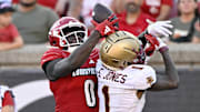 Sep 23, 2023; Louisville, Kentucky, USA;  Louisville Cardinals wide receiver Chris Bell (0) attempts to catch a pass over Boston College Eagles defensive back Elijah Jones (1) during the second half at L&N Federal Credit Union Stadium. Louisville defeated Boston College 56-28. Mandatory Credit: Jamie Rhodes-Imagn Images