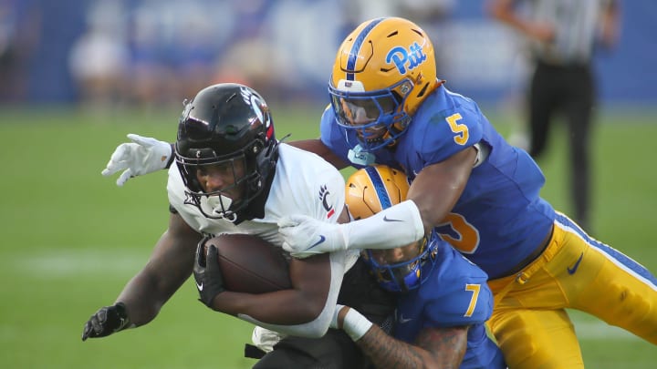 Cincinnati Bearcats Corey Kiner (21) gets tackled by Pittsburgh Panthers Javon McIntyre (7) and Phillip O'Brien Jr. (5) during the first half at Acrisure Stadium in Pittsburgh, PA on September 9, 2023