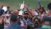 J.J. Spaun hoists his trophy in the air while celebrating his US Open Championship win at Oakmont Country Club.