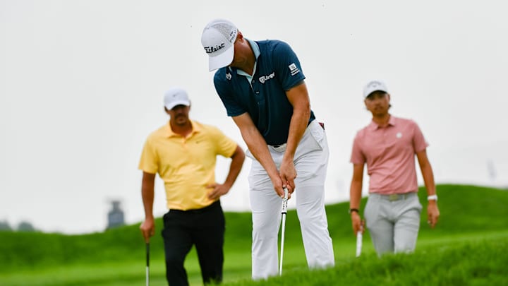 Golf stars Brooks Koepka and Min Woo Lee watch as Justin Thomas putts during the 125th U.S. Open at Oakmont Country Club 