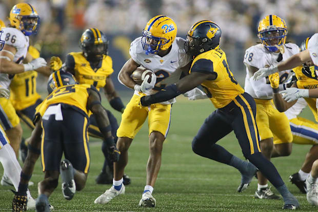 Pittsburgh wide receiver Kenny Johnson is tackled by West Virginia linebacker Trey Lathan during the 2023 matchup.