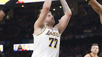 Apr 6, 2025; Oklahoma City, Oklahoma, USA; Los Angeles Lakers guard Luka Doncic (77) drives to the basket between Oklahoma City Thunder guard Shai Gilgeous-Alexander (2) and forward Jalen Williams (8) during the second quarter at Paycom Center. Mandatory Credit: Alonzo Adams-Imagn Images