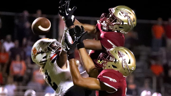 Riverdale's Zyntreacs Otey (9) and Riverdale's Camryn Darden (2) both try to intercept a pass 