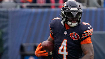 Oct 19, 2025; Chicago, Illinois, USA; Chicago Bears running back D'Andre Swift (4) runs with the ball against New Orleans Saints defensive end Carl Granderson (96)  during the second half at Soldier Field.