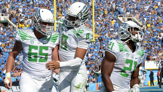 Oct 11, 2014; Pasadena, CA, USA; Oregon Ducks players Stetzon Bair (65), Marcus Mariota (8) and Royce Freeman (21) celebrate 