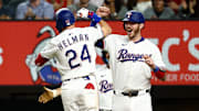 Texas Rangers center fielder Michael Helman (24) celebrates with Texas Rangers catcher Jonah Heim (28) after hitting a two-run home run during the fifth inning against the Milwaukee Brewers at Globe Life Field.