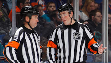 Referees speak during a break in NHL play (Getty Images)