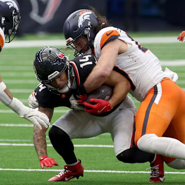 Nov 2, 2025; Houston, Texas, USA; Denver Broncos linebacker Alex Singleton (49) tackles Houston Texans wide receiver Jaylin Noel (14 during the second half at NRG Stadium. Mandatory Credit: Thomas Shea-Imagn Images