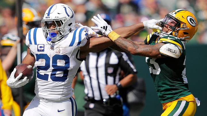 Indianapolis Colts running back Jonathan Taylor (28) stiff arms Green Bay Packers cornerback Jaire Alexander (23) on a first down run during their football game Sunday, September 15, 2024, at Lambeau Field in Green Bay, Wisconsin.