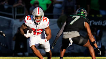 Oct 12, 2024; Eugene, Oregon, USA; Ohio State Buckeyes running back TreVeyon Henderson (32) runs at Oregon Ducks defensive back Jabbar Muhammad (7) during the first half of the NCAA football game at Autzen Stadium