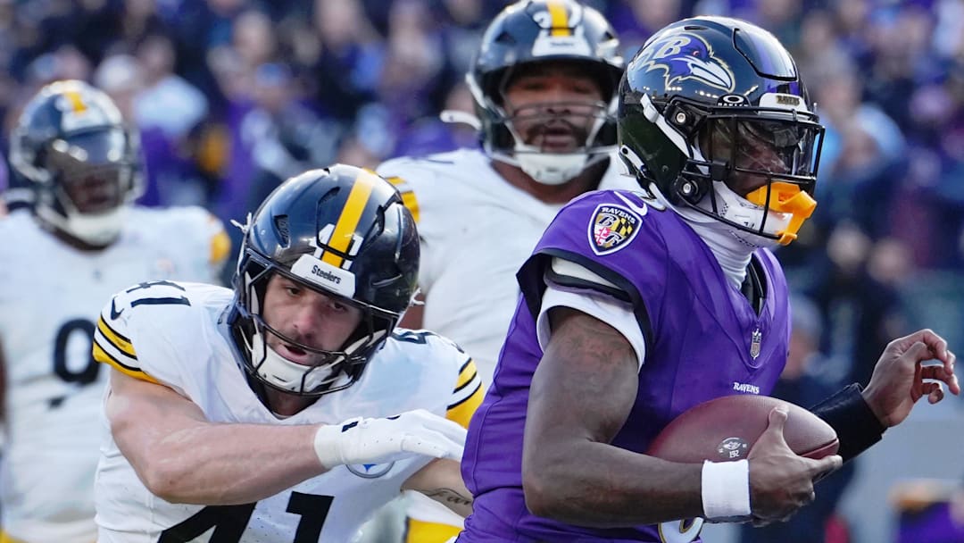 Baltimore Ravens quarterback Lamar Jackson runs with the ball against Pittsburgh Steelers linebacker Payton Wilson.