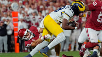 Oklahoma Sooners linebacker Owen Heinecke (38) brings down Michigan Wolverines quarterback Bryce Underwood (19) 