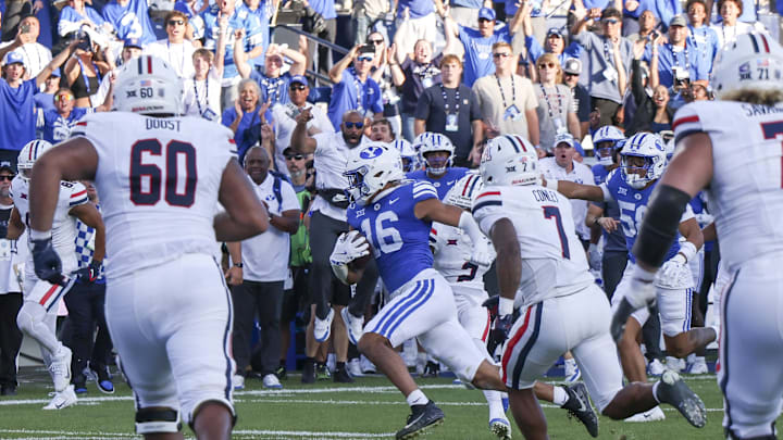 Oct 12, 2024; Provo, Utah, USA; Brigham Young Cougars linebacker Isaiah Glasker (16) runs an interception back for a touchdown against the Arizona Wildcats during the fourth quarter at LaVell Edwards Stadium. Mandatory Credit: Rob Gray-Imagn Images
