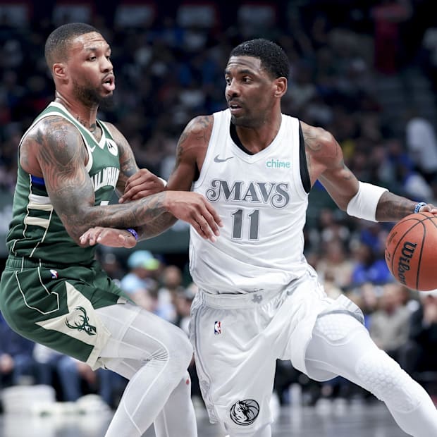 Dallas Mavericks goalkeeper Kyrie Irving (11) controls the ball as a Milwaukee Bucks Damian Lillard goalkeeper