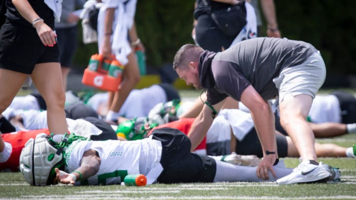 Oregon head coach Dan Canning helps wide receiver Tex Johnson stretch during the Ducks’ fall camp Wednesday, Aug. 7, 2024, at the Hatfield-Dowlin Complex in Eugene, Ore.