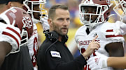 Sep 4, 2021; Pittsburgh, Pennsylvania, USA;   Massachusetts Minutemen assistant head coach 
Luke Paschall (middle) speaks to his team in the huddle 
against the Pittsburgh Panthers during the second quarter at Heinz Field. Mandatory Credit: Charles LeClaire-Imagn Images