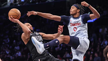 Feb 5, 2025; Brooklyn, New York, USA;  Brooklyn Nets forward Tosan Evbuomwan (12) looks to drive past Washington Wizards guard Bilal Coulibaly (0) in the fourth quarter at Barclays Center. Mandatory Credit: Wendell Cruz-Imagn Images