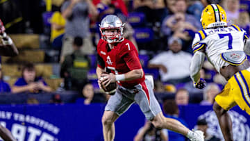 Sep 7, 2024; Baton Rouge, Louisiana, USA; Nicholls State Colonels quarterback Pat McQuaide (7) rolls out of the pocket against LSU Tigers linebacker Harold Perkins Jr. (7) during the second half at Tiger Stadium. Mandatory Credit: Stephen Lew-Imagn Images