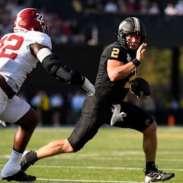 Oct 5, 2024; Nashville, Tennessee, USA;  Vanderbilt Commodores quarterback Diego Pavia (2) breaks the tackle of Alabama Crimson Tide defensive lineman LT Overton (22) during the first half at FirstBank Stadium. Mandatory Credit: Steve Roberts-Imagn Images