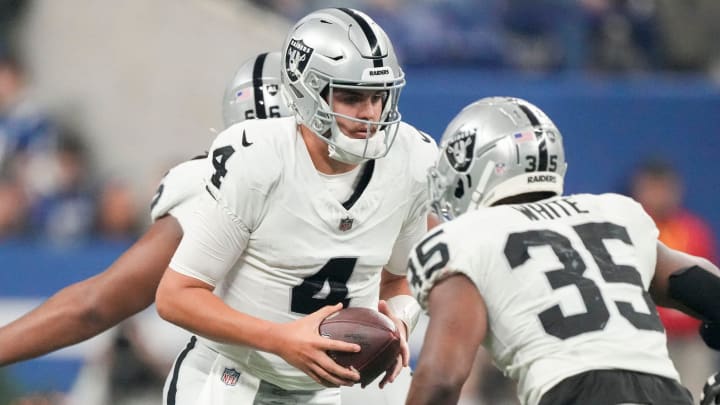 Las Vegas Raiders quarterback Aidan O'Connell (4) turns to hand the ball to Las Vegas Raiders running back Zamir White (35) on Sunday, Dec. 31, 2023, during a game against the Las Vegas Raiders at Lucas Oil Stadium in Indianapolis.