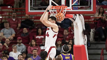 Feb 12, 2025; Fayetteville, Arkansas, USA;  Arkansas Razorbacks forward Zvonimir Ivisic (44) dunks in front of LSU Tigers guard Jordan Sears (1) and forward Corey Chest (11) during the first half at Bud Walton Arena. Arkansas won 70-58.  Mandatory Credit: Brett Rojo-Imagn Images