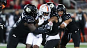 A host of U of L defenders brought down Virginia's Malik Washington (4) during their game at the L&N Stadium in Louisville, Ky. on Nov. 9, 2023.