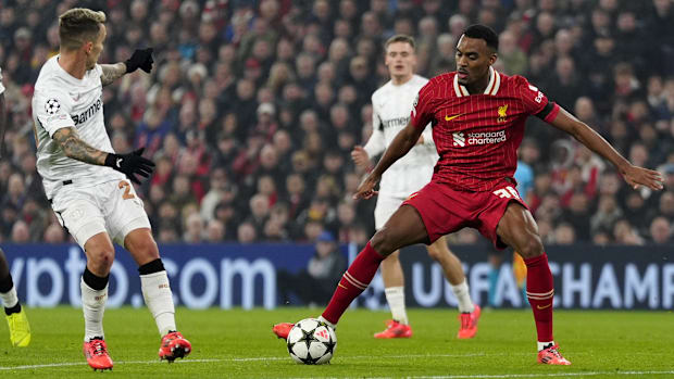 Liverpool's Ryan Gravenberch (centre) and Bayer Leverkusen's Alejandro Grimaldo (left) fight for the ball during the UEFA Ch