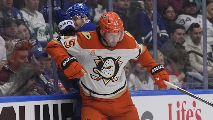Mar 12, 2026; Toronto, Ontario, CAN; Anaheim Ducks defenseman Jacob Trouba (65) checks Toronto Maple Leafs defenseman Oliver Ekman-Larsson (95) into the boards during the first period at Scotiabank Arena. Mandatory Credit: John E. Sokolowski-Imagn Images