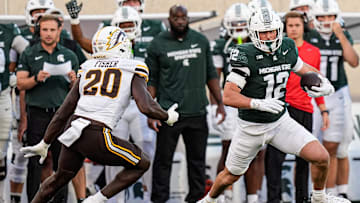 Michigan State tight end Jack Velling (12) makes a catch against Western Michigan defensive end Kershawn Fisher (20) during the first half at Spartan Stadium in East Lansing on Friday, August 29, 2025.