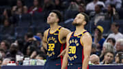 Jan 7, 2025; San Francisco, California, USA;  Golden State Warriors forward Trayce Jackson-Davis (32) and guard Stephen Curry (30) watch a reply during the fourth quarter against the Miami Heat at Chase Center. Mandatory Credit: John Hefti-Imagn Images