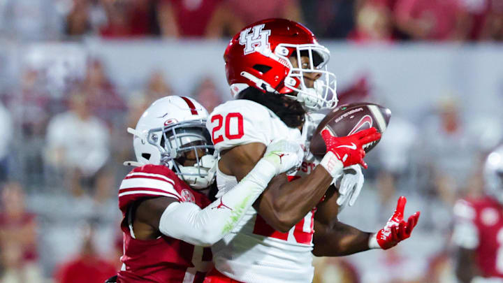 Sep 7, 2024; Norman, Oklahoma, USA;  Houston Cougars defensive back Jeremiah Wilson (20) makes an interception in front of Oklahoma Sooners wide receiver Zion Ragins (81) but it is called back for a penalty during the second half at Gaylord Family-Oklahoma Memorial Stadium. Mandatory Credit: Kevin Jairaj-Imagn Images