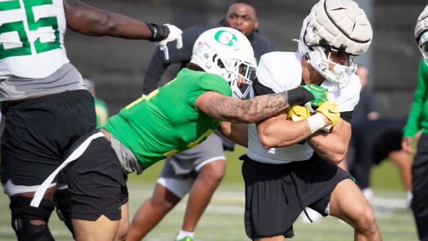 Oregon running back Jayden Limar attempts to break a tackle by defensive back Kobe Savage during practice with the Ducks 