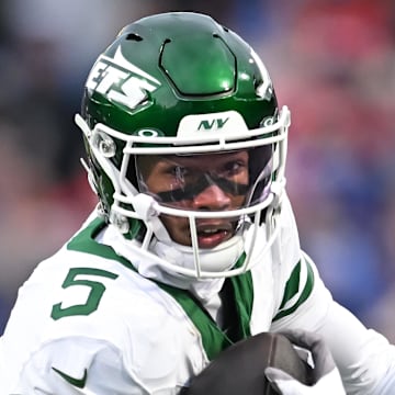 Dec 29, 2024; Orchard Park, New York, USA; New York Jets wide receiver Garrett Wilson (5) runs with the ball after making a catch against the Buffalo Bills in the first quarter at Highmark Stadium. Mandatory Credit: Mark Konezny-Imagn Images