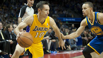 Oct 18, 2013; Shanghai, China; Los Angeles Lakers guard Steve Nash (10) dribbles the ball as Golden State Warriors guard Stephen Curry (30) defends during the first quarter at Mercedes-Benz Arena. Mandatory Credit: Danny La-Imagn Images