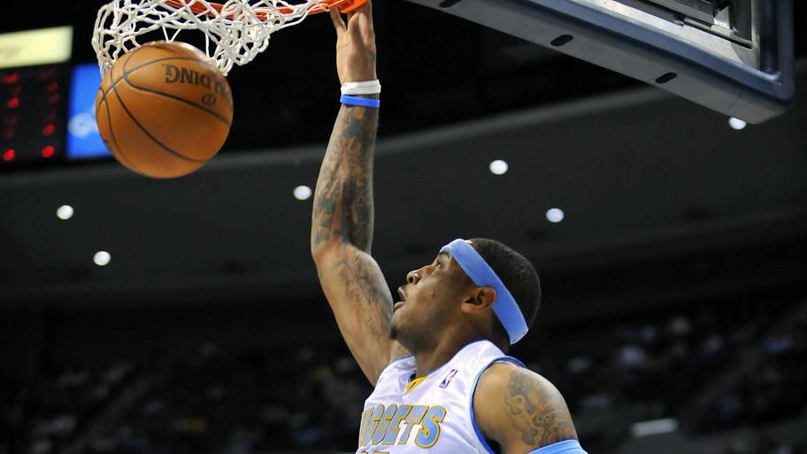 Denver Nuggets forward Carmelo Anthony dunks the basketball over a Golden State Warriors defender.