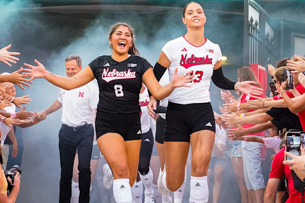 Nebraska Cornhuskers outside hitter Merritt Beason (13) and libero Lexi Rodriguez (8) run out of the tunnel.