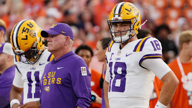LSU head coach Brian Kelly and quarterback Garrett Nussmeier (18) look on during warmups before the game against Clemson