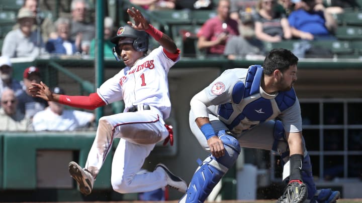 Rochester's Darren Baker slides safely home ahead of the throw to Buffalo catcher Stevie Berman, scoring on a double by teammate Jack Dunn in the second inning.