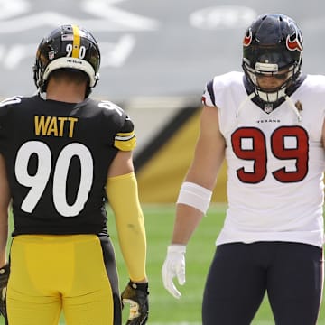 Sep 27, 2020; Pittsburgh, Pennsylvania, USA; NFL referee Shawn Smith (14) flips the coin as brothers Pittsburgh Steelers outside linebacker T.J. Watt (90) and Houston Texans defensive end J.J. Watt (99) take part before their game against at Heinz Field. The Steelers won 28-21