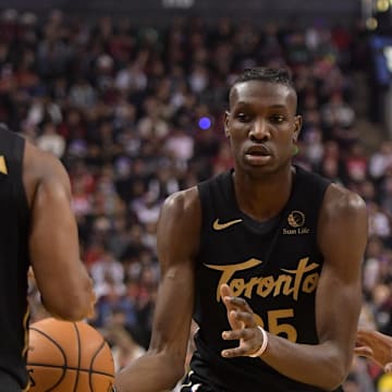 Dec 25, 2019; Toronto, Ontario, CAN;  Toronto Raptors forward Chris Boucher (25) passes the ball to guard Kyle Lowry (7) in the first half against Boston Celtics at Scotiabank Arena. Mandatory Credit: Dan Hamilton-Imagn Images