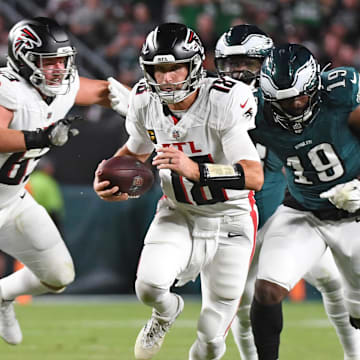 Sep 16, 2024; Philadelphia, Pennsylvania, USA; Atlanta Falcons quarterback Kirk Cousins (18) runs past Philadelphia Eagles linebacker Josh Sweat (19) during the second quarter at Lincoln Financial Field. Mandatory 