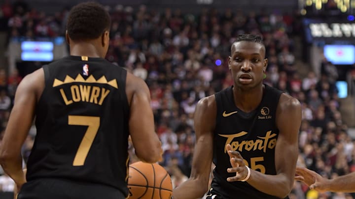 Dec 25, 2019; Toronto, Ontario, CAN;  Toronto Raptors forward Chris Boucher (25) passes the ball to guard Kyle Lowry (7) in the first half against Boston Celtics at Scotiabank Arena. Mandatory Credit: Dan Hamilton-Imagn Images