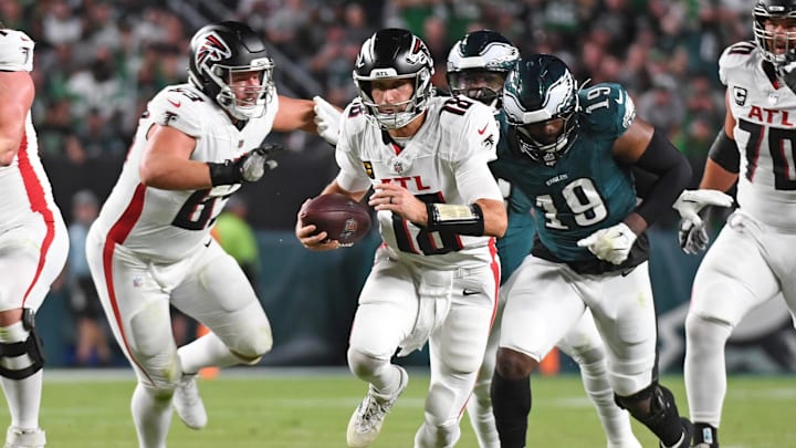 Sep 16, 2024; Philadelphia, Pennsylvania, USA; Atlanta Falcons quarterback Kirk Cousins (18) runs past Philadelphia Eagles linebacker Josh Sweat (19) during the second quarter at Lincoln Financial Field. Mandatory 