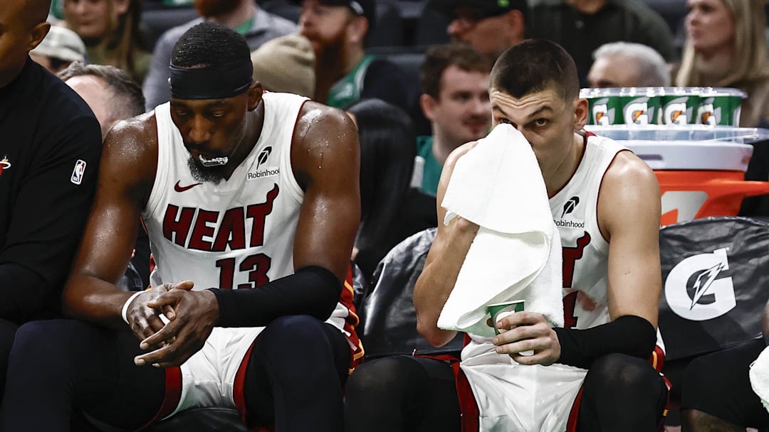 Dec 2, 2024; Boston, Massachusetts, USA; Miami Heat players (left to right) center Bam Adebayo (13), guard Tyler Herro (14), guard Terry Rozier (2) and forward Duncan Robinson (55) sit on the bench during the fourth quarter of their loss to the Boston Celtics at TD Garden. Mandatory Credit: Winslow Townson-Imagn Images