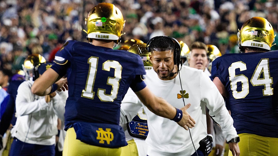 Oct 18, 2025; South Bend, Indiana, USA; Notre Dame Fighting Irish head coach Marcus Freeman celebrates with quarterback CJ Carr (13) in the first half against the Southern California Trojans at Notre Dame Stadium. Mandatory Credit: Trevor Ruszkowski-Imagn Images