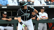 Jun 15, 2025; Omaha, Neb, USA;  Coastal Carolina Chanticleers catcher Caden Bodine (17) reaches on an infield error by the Oregon State Beavers during the first inning at Charles Schwab Field. 