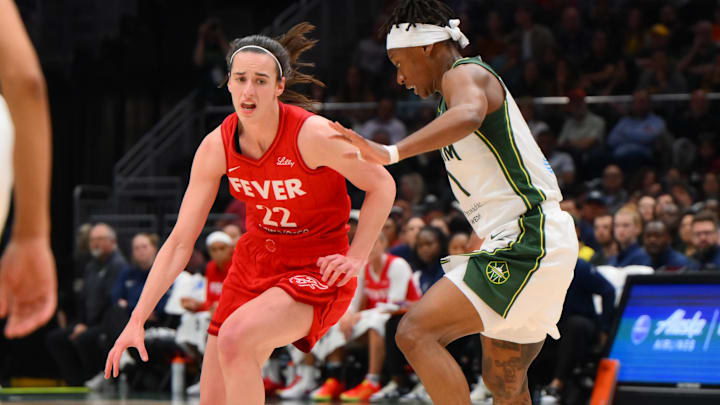 Jun 24, 2025; Seattle, Washington, USA; Indiana Fever guard Caitlin Clark (22) advances the ball while guarded by Seattle Storm guard Erica Wheeler (17) during the second half at Climate Pledge Arena. Mandatory Credit: Steven Bisig-Imagn Images