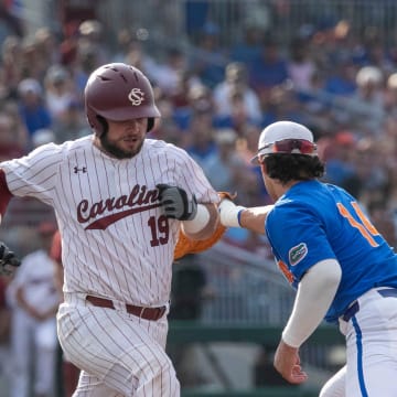Gators utility Jac Caglianone (14) with the catch at first for the out against Gamecocks catcher Cole Messina (19) in Game 2 of the NCAA Super Regional against Florida, Saturday, June 10, 2023, at Condron Family Ballpark in Gainesville, Florida. The Gators beat the Gamecocks 4-0 and are headed to the College World Series in Omaha.  [Cyndi Chambers/ Gainesville Sun] 2023