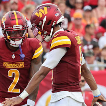 Sep 8, 2024; Tampa, Florida, USA;  Washington Commanders quarterback Jayden Daniels (5) celebrates with wide receiver Dyami Brown (2) after he scored a touchdown during the second half at Raymond James Stadium. Mandatory Credit: Kim Klement Neitzel-Imagn Images