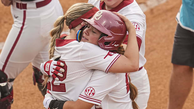 Oklahoma infielder Gabbie Garcia (42) (with helmet) reacts with teammates after hitting a homer against Arkansas